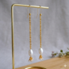 Jewelry product photography of long gold and pearl earrings.