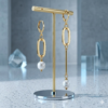 Pair of asymmetric earrings with 18k gold plating, showing one short oval link pearl drop and one long linear bar pearl drop.