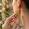 luxury festive statement earrings in anti-tarnish brass featuring layered pearl clusters and deep purple stones.