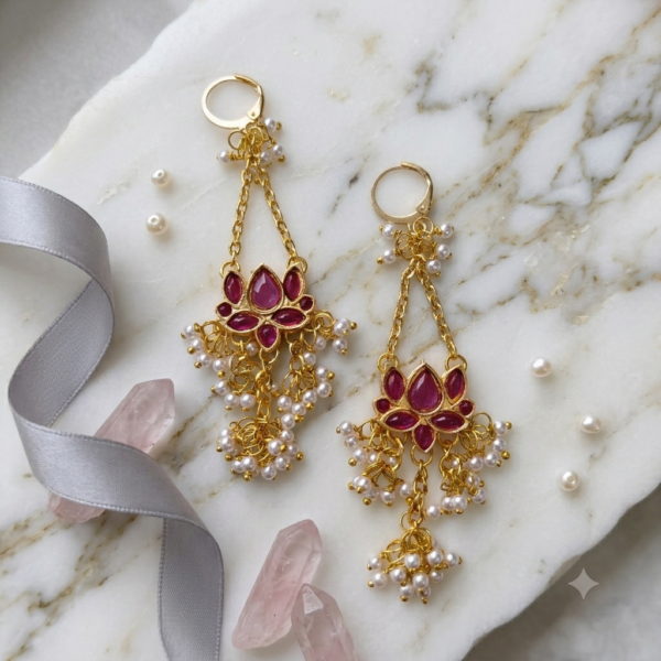 Front view of Jalja lotus-inspired purple Kundan chandelier earrings with gold chain links and white pearl detailing.